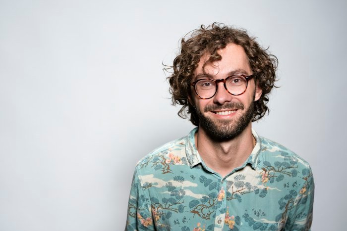 Portrait d'Hugo Lambert, barbe et lunettes, souriant