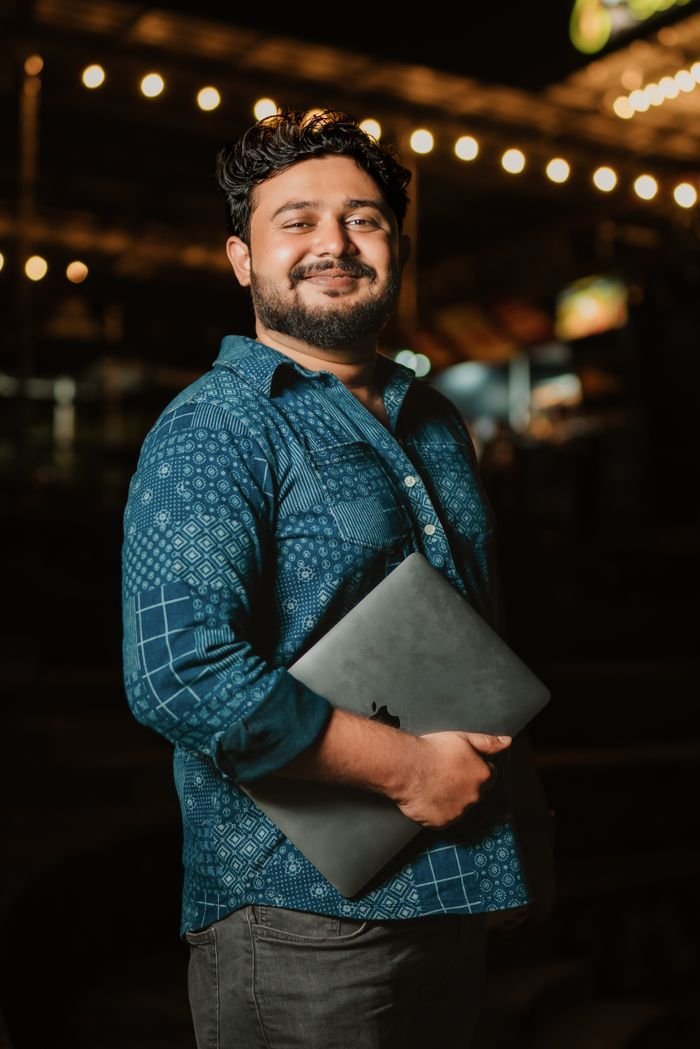 Portrait de Malik Benali, ordinateur portable sous le bras