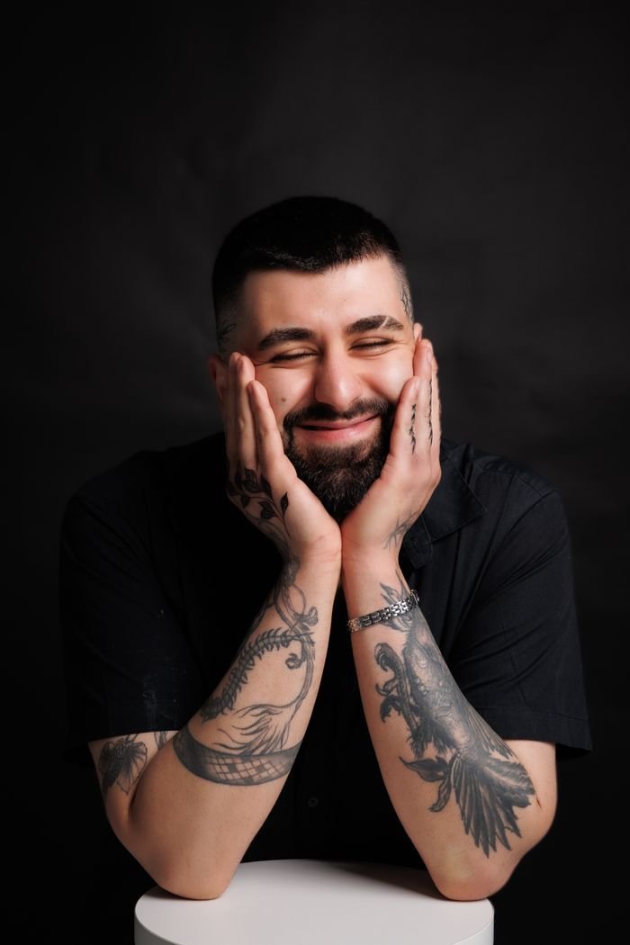 Portrait de Nathan Ferreira, souriant, les mains sous le menton