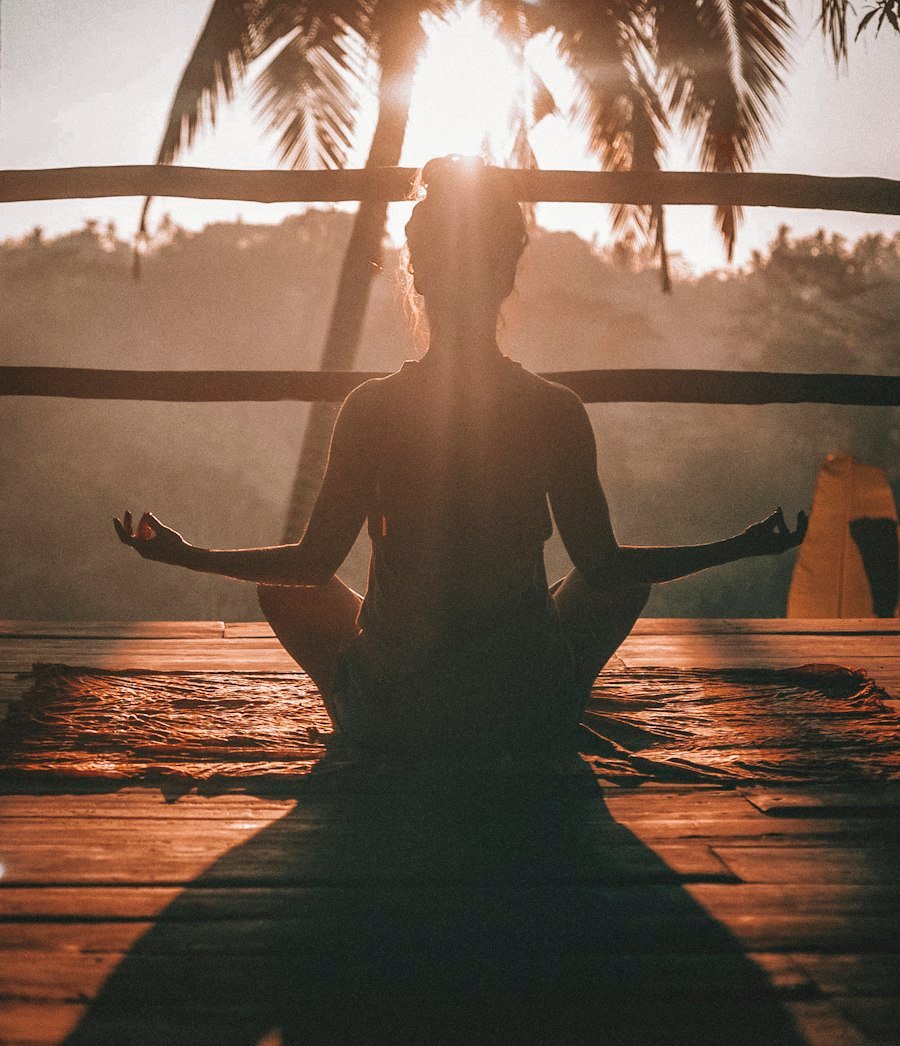 Une femme médite en position de yoga sur un parquet